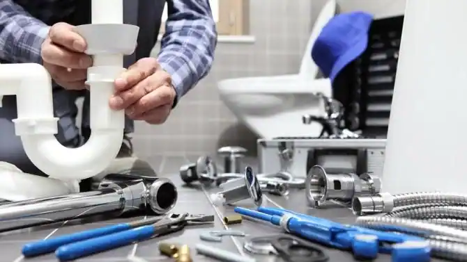 Installateur reinigt den Siphon eines Waschbeckens
